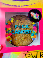 Cookie box featuring a decorated chocolate chip cookie cake with colorful frosting, sprinkles, and bold blue lettering reading