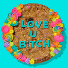 Specialty cookie cake with vibrant frosting, sprinkles, and bold blue lettering spelling