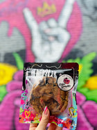 A packaged cookie held against a vibrant graffiti mural background.