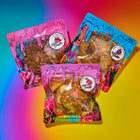 Gourmet lactation cookies in vibrant Rebel Daughter Cookies packaging, featuring assorted flavors against a colorful gradient background.