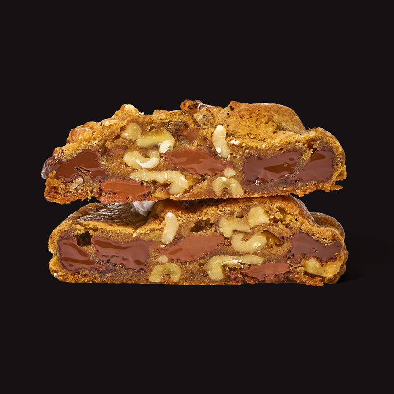 Chocolate chip and walnut specialty cookies with melted chocolate and crunchy walnuts on a black background.