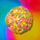 Colorful cereal white chocolate specialty cookies coated in vibrant cereal pieces and edible glitter on a rainbow gradient background.