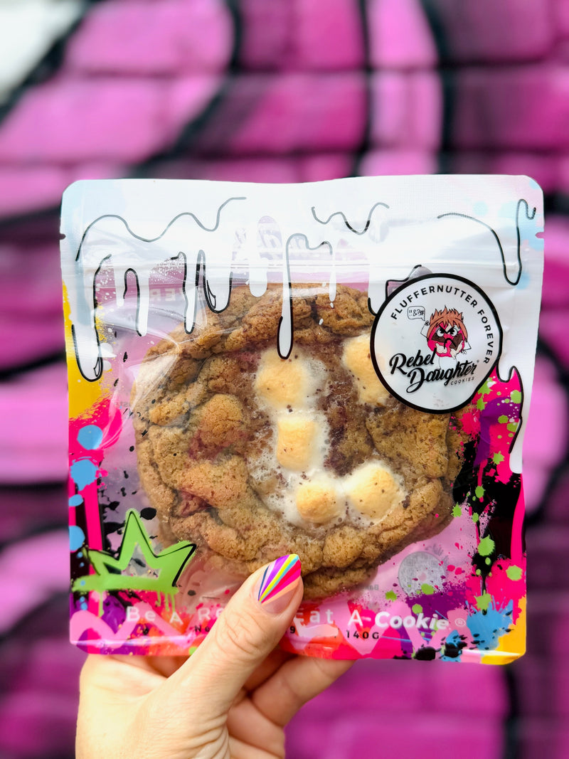 A packaged peanut butter and marshmallow cookie held against a vibrant pink graffiti background.