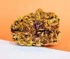 A Rebel Daughter oatmeal chocolate chunk lactation cookie in half and stacked against an orange background