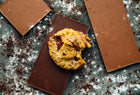 A Rebel Daughter oatmeal chocolate chunk lactation cookie surrounded by chocolate bars