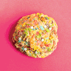 A gif of a colorful, gourmet Rebel Daughter White Unicorn cookie covered in Fruity Pebbles