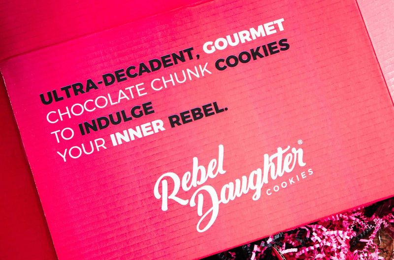 The pink inside lid of a Rebel Daughter Cookies shipping box with words