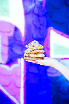 A stack of Rebel Daughter Cookies in front of a purple and blue mural
